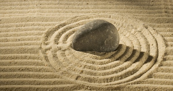 Still life of a stone on sand.