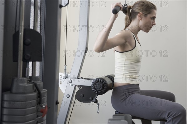 Woman working with resistance machine.