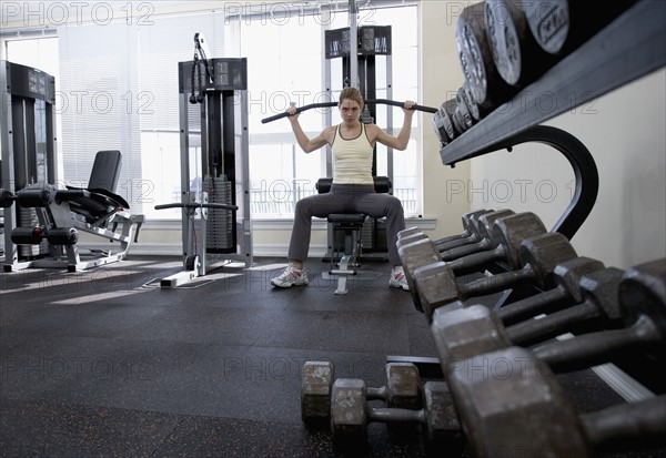 Woman working with resistance machine.