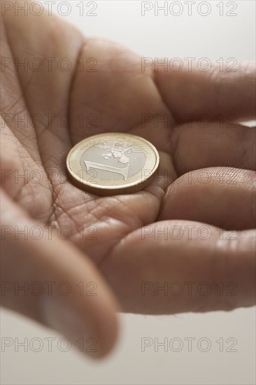 Closeup of Euro coin in palm.