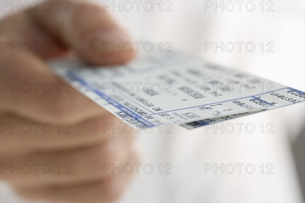 Closeup of hand holding tickets.