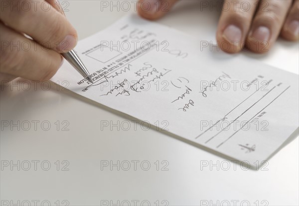Closeup of hands signing prescription.