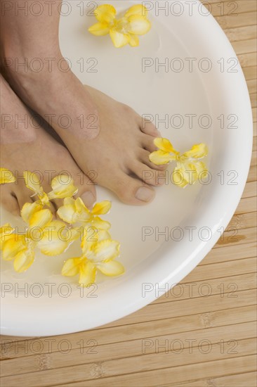 Feet in footbath with flowers.