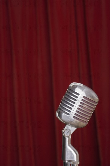 Old fashioned microphone with red curtain.