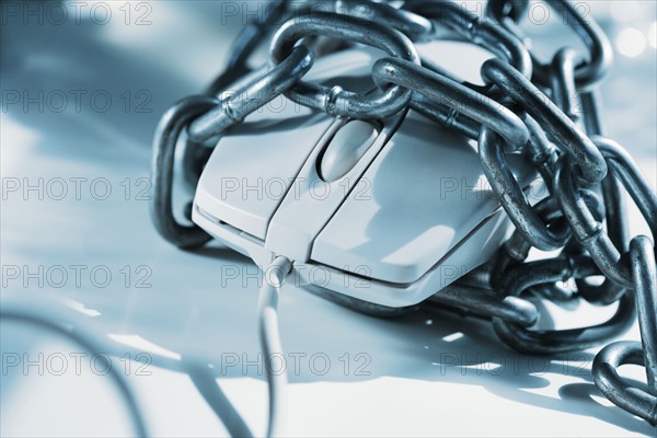 Closeup of computer mouse covered in chains.