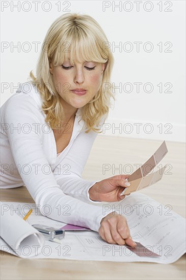 Woman with color samples and blueprints.