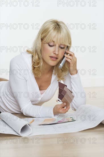 Woman with color samples and blueprints.