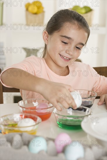 Girl coloring Easter eggs.