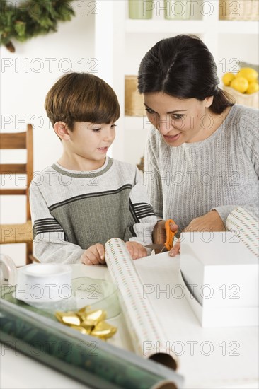 Mother and son wrapping Christmas gifts.