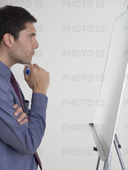 Businessman contemplating what to write.