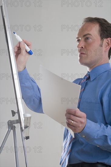 Businessman writing on presentation board.