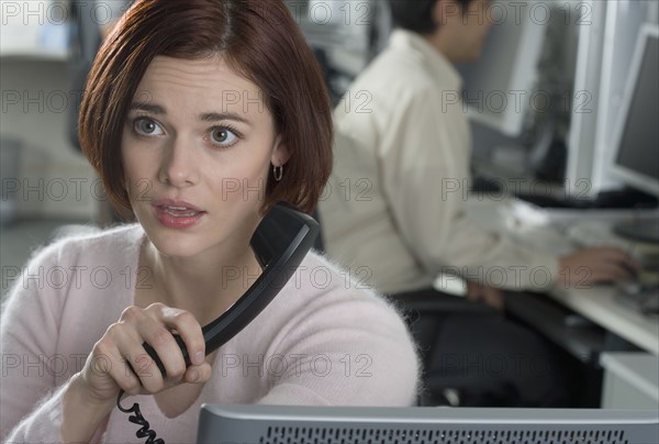 Woman talking on phone in office.