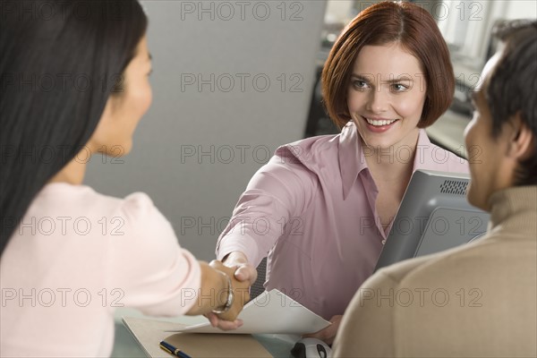 Businesswoman shaking hands in office.