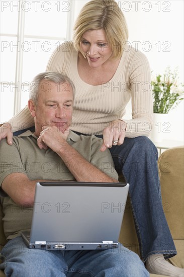 Couple using laptop computer at home.