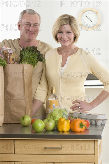 Portrait of couple unloading groceries.