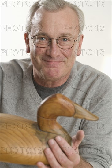 Man holding handmade wooden duck.