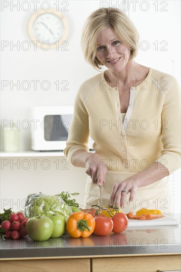 Portrait of woman cutting vegetables.