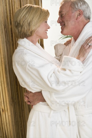 Couple wearing robes embracing.