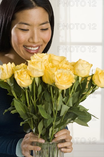 Woman arranging flowers in vase.