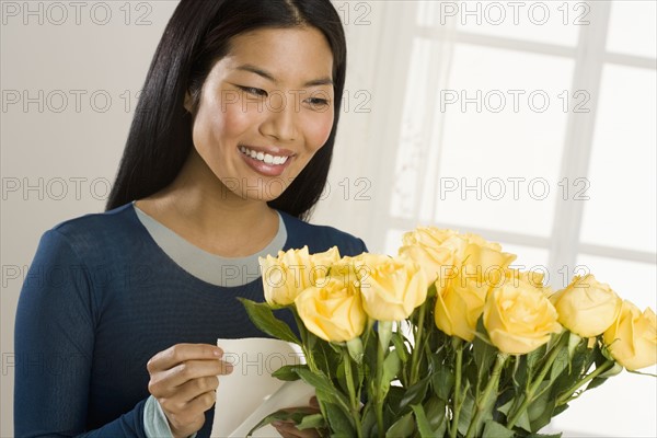 Woman admiring bouquet of roses.