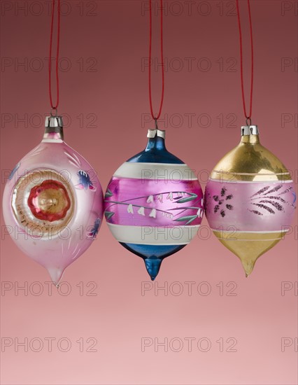 Three hanging Christmas ornanaments.