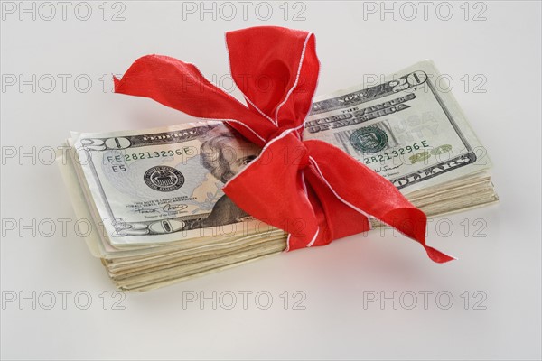 A stack of money with a bow.
