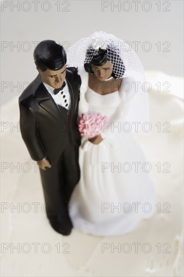 Bride and groom on top of wedding cake.