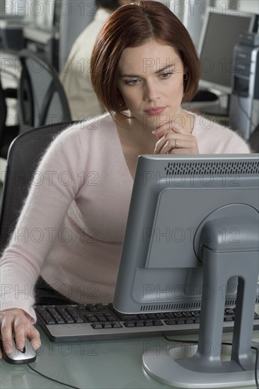 Woman working at computer in office.