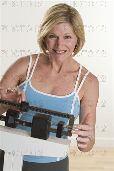 Portrait of woman weighing herself.