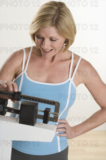 Woman weighing herself.