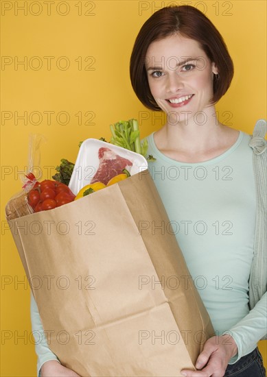 Woman carrying bag of groceries.