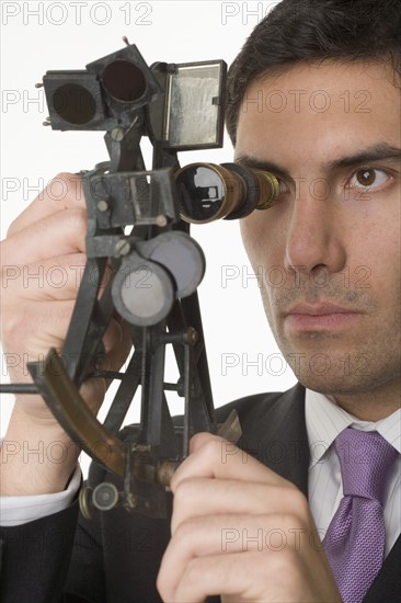 Man holding a sextant.