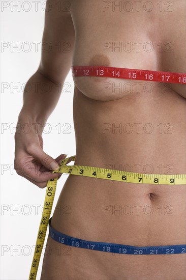Nude female taking measurements.