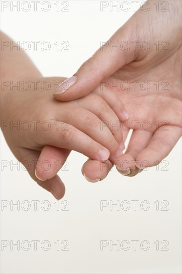 Baby holding hands with mother.