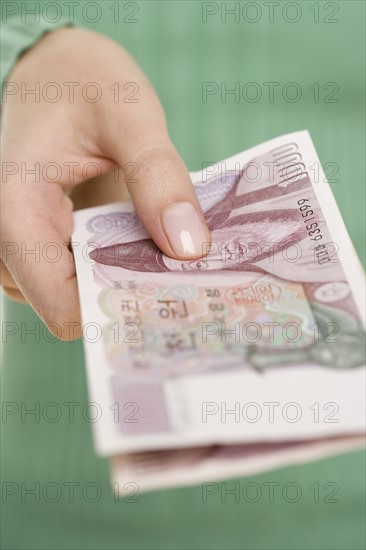 Woman holding Korean money.