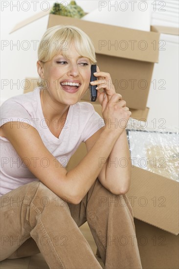 Woman on moving day talking on mobile phone.