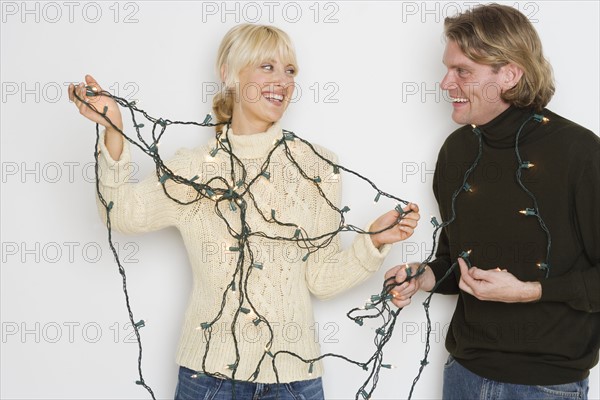 Couple untangling holiday lights.