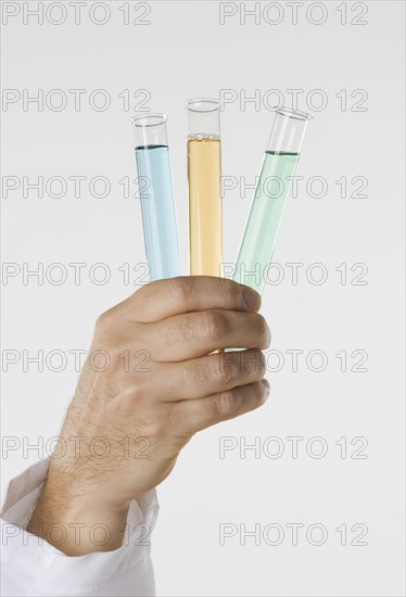 Hand holding test tubes.