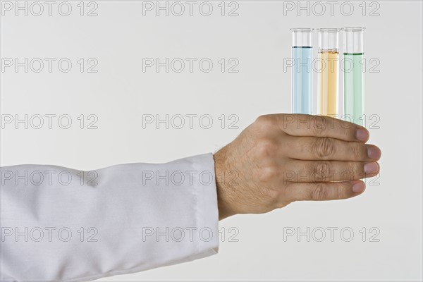 Hand holding test tubes.