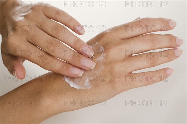 Female hand applying moisturizer.