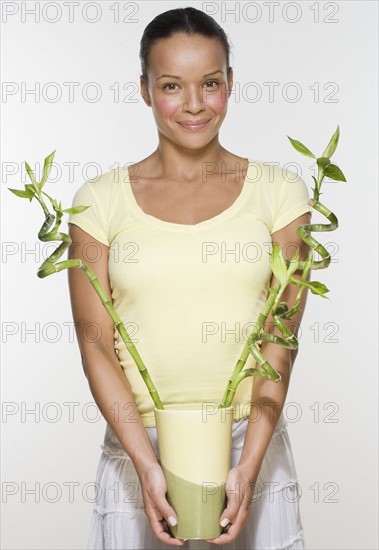 Woman holding plants in vase.