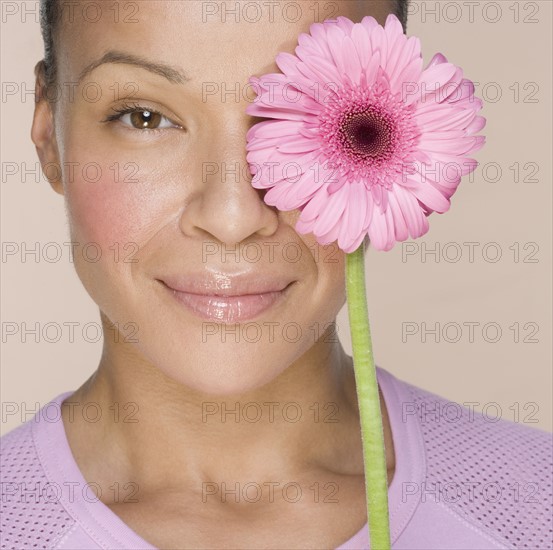 Woman with flower over one eye.