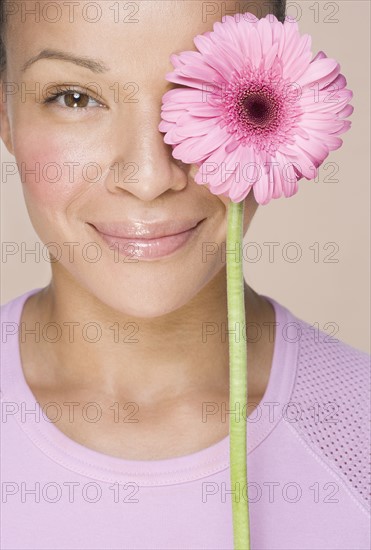 Woman with flower over one eye.