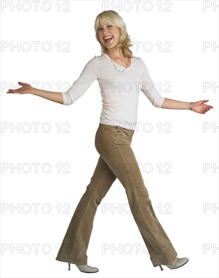 Woman walking with arms outstretched.