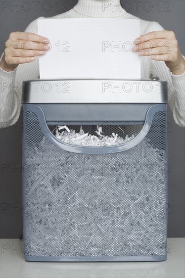 Woman using a paper shredder.