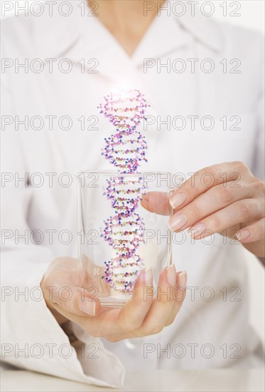 Hands holding DNA in beaker.