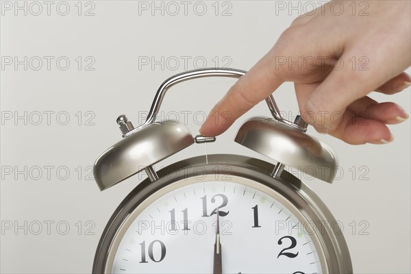 Woman turning off alarm clock.