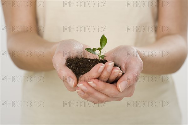 Woman holding seedling.