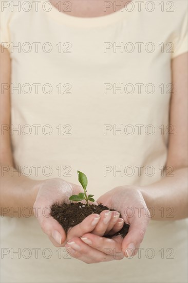 Woman holding seedling.