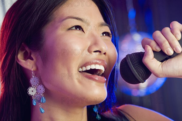 Woman singing into microphone.